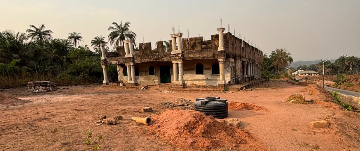 Wide exterior view of the unfinished church building and its surrounding site